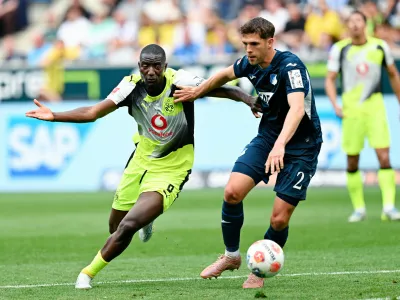 Dortmund's Serhou Guirassy, left, and Hoffenheim's Robin Hranac battle for the ball during their German Bundesliga soccer match in Sinsheim, Germany, Saturday, April 18, 2026. (Uwe Anspach/dpa via AP)