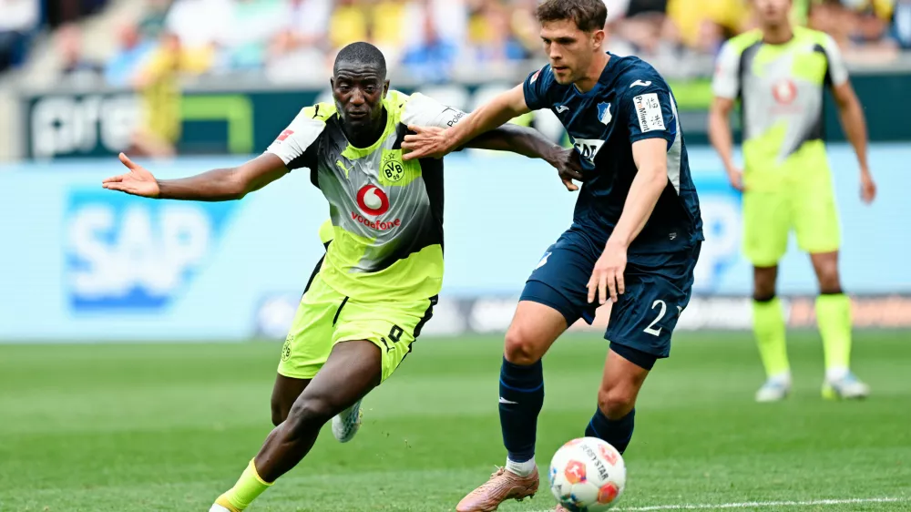 Dortmund's Serhou Guirassy, left, and Hoffenheim's Robin Hranac battle for the ball during their German Bundesliga soccer match in Sinsheim, Germany, Saturday, April 18, 2026. (Uwe Anspach/dpa via AP)
