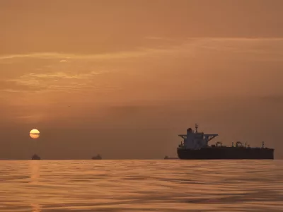 The sun rises behind tankers anchored in the Strait of Hormuz off the coast of Qeshm Island, Iran, Saturday, April 18, 2026. (AP Photo/Asghar Besharati)