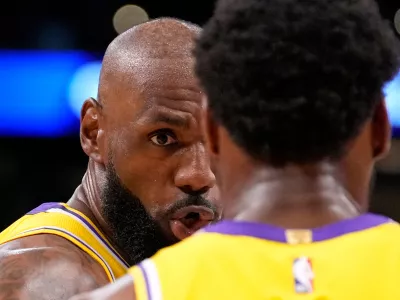 Los Angeles Lakers forward LeBron James, left, talks to guard Bronny James during the first half in Game 1 of a first-round NBA playoffs basketball series against the Houston Rockets, Saturday, April 18, 2026, in Los Angeles. (AP Photo/Mark J. Terrill)