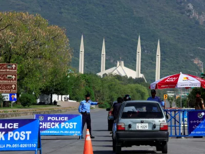 A police officer gestures to a vehicle at a check post along a road near Faisal Masjid, as Pakistan prepares to host the U.S. and Iran for the second phase of peace talks in Islamabad, Pakistan April 19, 2026. REUTERS/Akhtar Soomro