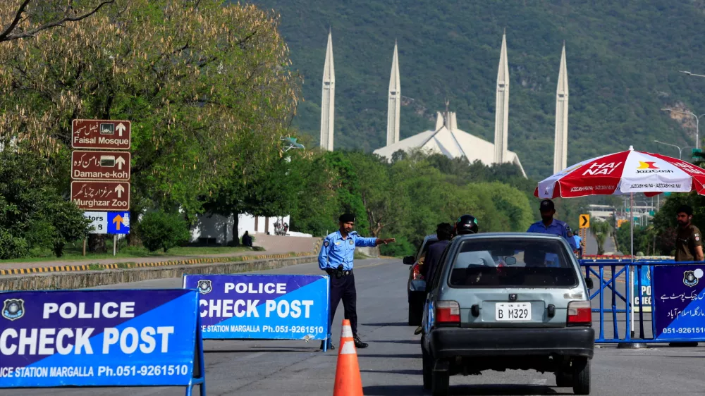 A police officer gestures to a vehicle at a check post along a road near Faisal Masjid, as Pakistan prepares to host the U.S. and Iran for the second phase of peace talks in Islamabad, Pakistan April 19, 2026. REUTERS/Akhtar Soomro