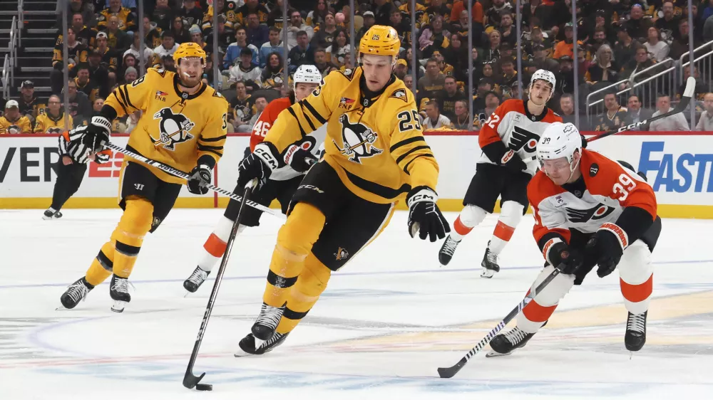 Apr 20, 2026; Pittsburgh, Pennsylvania, USA; Pittsburgh Penguins left wing Elmer Soderblom (25) moves the puck against Philadelphia Flyers right wing Matvei Michkov (39) during the first period in game two of the first round of the 2026 Stanley Cup Playoffs at PPG Paints Arena. Mandatory Credit: Charles LeClaire-Imagn Images