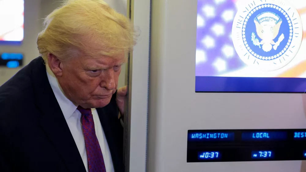U.S. President Donald Trump listens as he talks to members of the media aboard Air Force One en route to Joint Base Andrews, Maryland, U.S., April 17, 2026. REUTERS/Evan Vucci