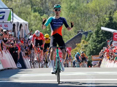 Paul Seixas of France crosses the finish line ahead of Mauro Schmid of Switzerland, rear left, and Ben Tulett of Britain, rear in yellow, to win the Belgian cycling classic Fleche Wallonne (Walloon Arrow), in Huy, Belgium, Wednesday, April 22, 2026. (AP Photo/Geert Vanden Wijngaert)