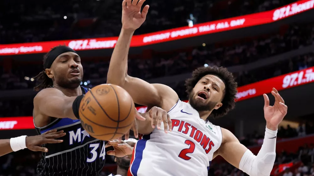 Orlando Magic center Wendell Carter Jr. (34) and Detroit Pistons guard Cade Cunningham (2) vie for the ball during the second half in Game 2 of a first-round NBA basketball playoffs series Wednesday, April 22, 2026, in Detroit. (AP Photo/Duane Burleson)