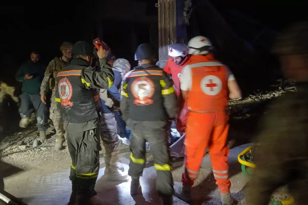 This photo released by the Lebanese Civil Defense, show Lebanese Red Cross volunteers and Civil Defense workers carrying the body of the Lebanese journalist Amal Khalil working for the daily Al-Akhbar newspaper killed in an Israeli airstrike, in al-Tiri village, south Lebanon, Wednesday, April 22, 2026. (Lebanese Civil Defense via AP)