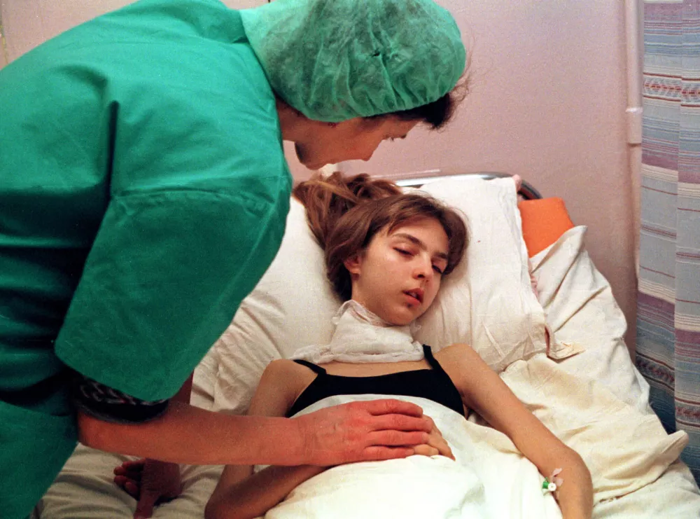 FILE - A medical worker attends to a 17-year-old girl recovering from surgery to remove her cancerous thyroid at the intensive therapy unit of the Endocrynology Institute in Kyiv, Ukraine, Nov. 30, 2000, nearly 15 years after the explosion and fire at the Chernobyl nuclear power plant. (AP Photo/Efrem Lukatsky, File)