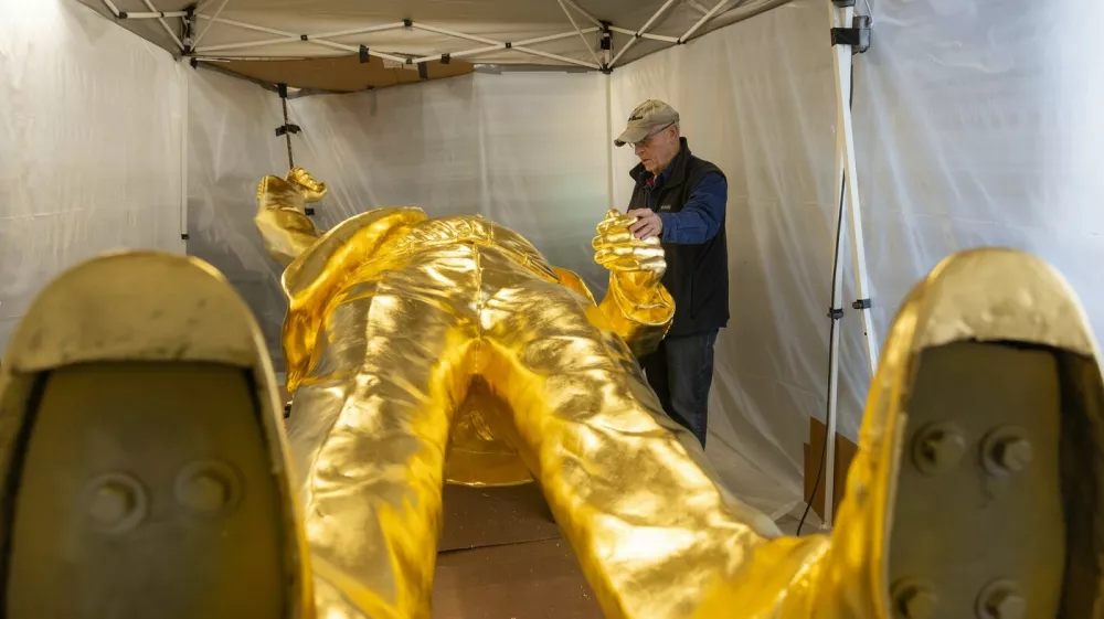 Alan Cottrill inspects the 15-foot tall golden Trump statue that he designed in Zanesville, Ohio, Jan. 29, 2026. At 15 feet tall, the statue of President Trump, mounted on its 7,000-pound pedestal, is about the height of a two-story building -- a giant effigy cast in bronze and finished with a thick layer of gold leaf.,Image: 1071895357, License: Rights-managed, Restrictions:, Model Release: no