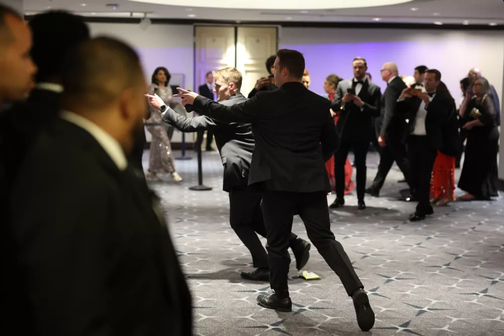 Guests exit during the White House Correspondents Dinner, Saturday, April 25, 2026, in Washington. (AP Photo/Tom Brenner)