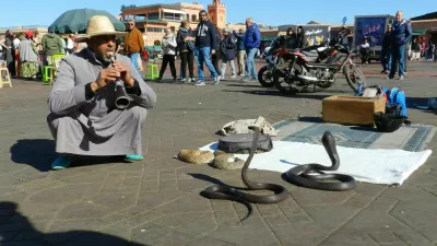 February 28, 2024 - Marrakesh, Morocco: A snake charmer plays his tune in front of two dangerous snakes in the market square of Marrakesh.