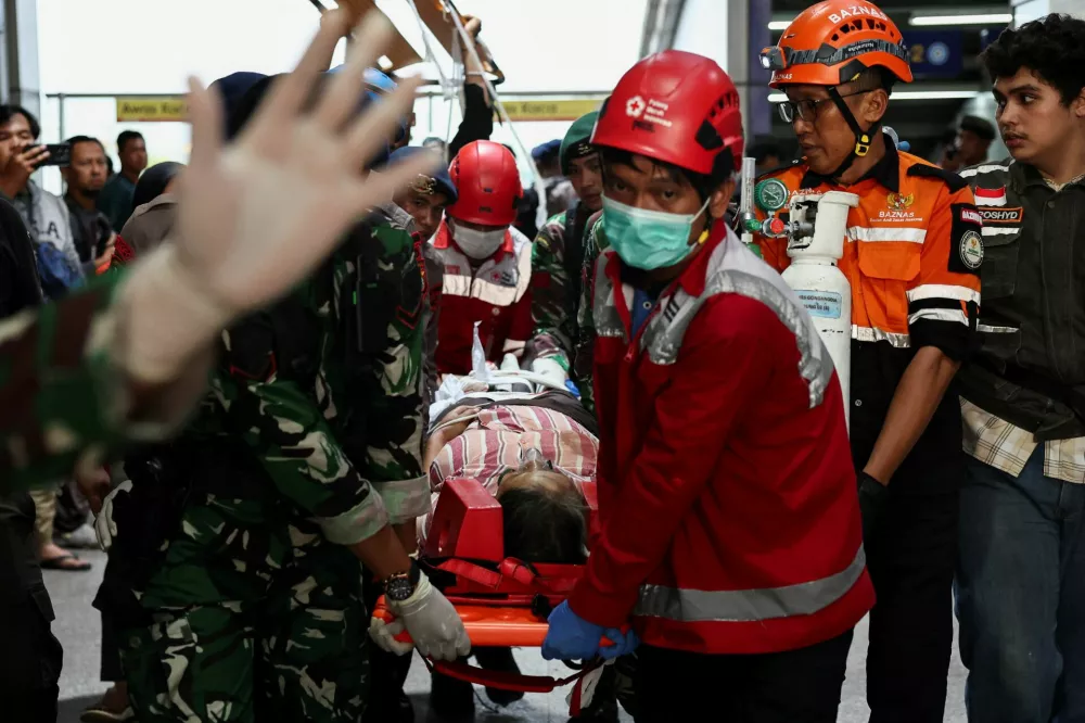 Rescuers transport a victim after a deadly collision between a commuter line train and a long-distance train, in Bekasi, on the outskirts of Jakarta, Indonesia, April 28, 2026. REUTERS/Willy Kurniawan