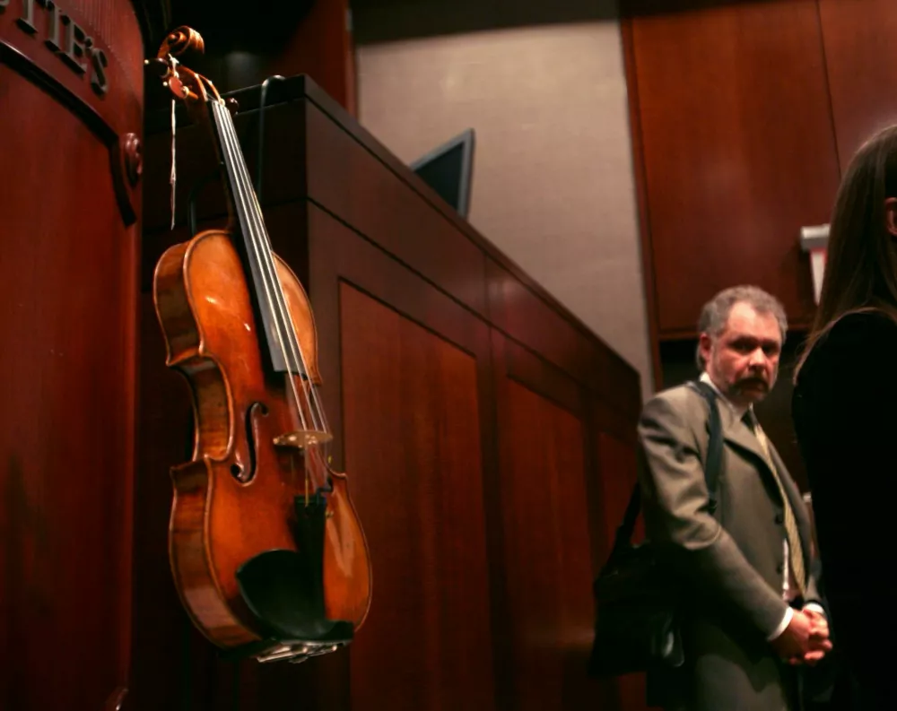 Ric Heinl stares at the violin known as the "Solomon, Ex-Lambert," made by Antonio Stradivari in 1729 after buying it at Christies in New York, Monday, April 2, 2007. Heinl bought the violin from the property of the late Seymour Solomon for $2.4 million. (AP Photos/Bebeto Matthews)