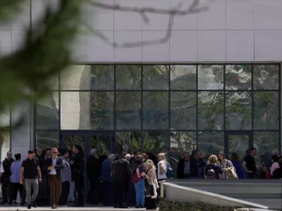 People gather outside a courthouse after a gunman opened fire leaving several people wounded in Athens, Tuesday, April 28, 2026. (AP Photo/Petros Giannakouris)