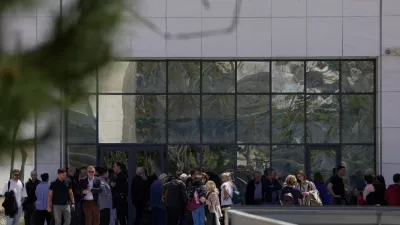 People gather outside a courthouse after a gunman opened fire leaving several people wounded in Athens, Tuesday, April 28, 2026. (AP Photo/Petros Giannakouris)