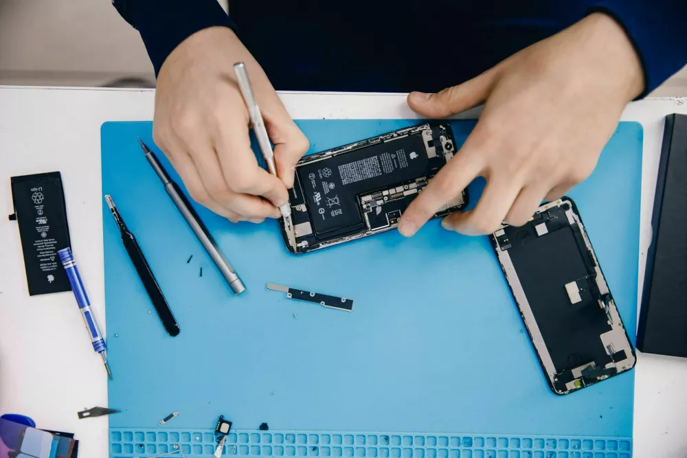 2J08W54 RUSSIA - February 20, 2022: Repair iPhone apple broken phone screen and replace used rechargeable batteries for recycling.