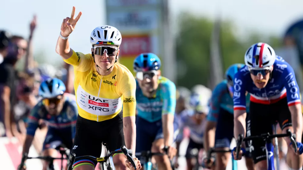 Winner Tadej Pogacar, left, from Slovenia, celebrates ahead of second placed Dorion Godon, right, from France, to win the second stage, a 173,1 km race between Rue and Vucherens, of the 79th Tour de Romandie UCI World Tour Cycling race, in Vuillens, Switzerland, Thursday, April 30, 2026. (Laurent Gillieron/Keystone via AP)