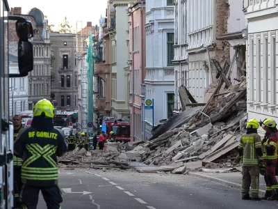 Police and firefighters stand near a collapsed house in the city center of Goerlitz, Germany, Monday, May 18, 2026. (Paul Glaser/dpa via AP)