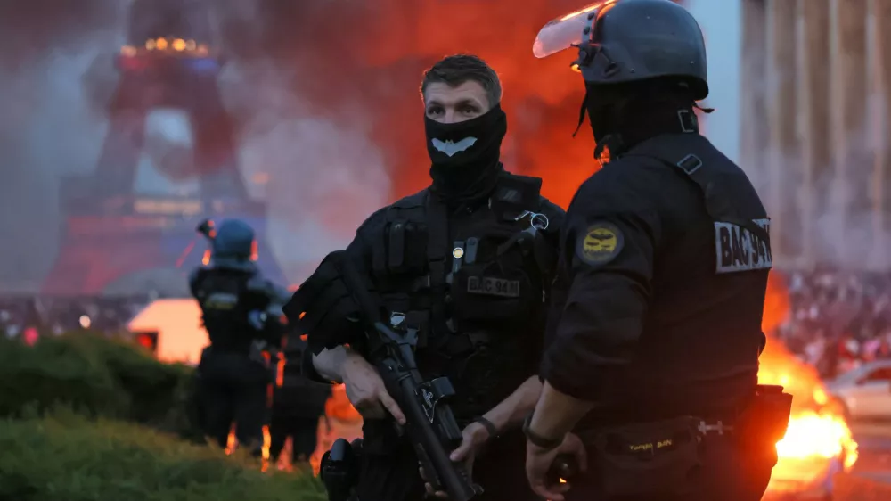 A car burns and fireworks explode as police watch PSG supporters celebrate in Paris, Saturday, May 30, 2026 after the Champions League final soccer match between Paris Saint-Germain and Arsenal that was played in Budapest. (AP Photo/Thomas Padilla)