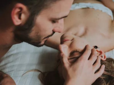 Close-Up Of Couple Embracing While Lying On Bed At Home