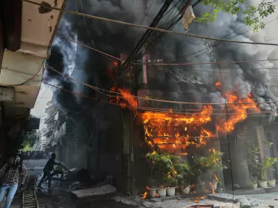 Local people attempt to douse a fire at a hotel in New Delhi, India, Wednesday, June 3, 2026. (AP Photo/Manish Swarup)