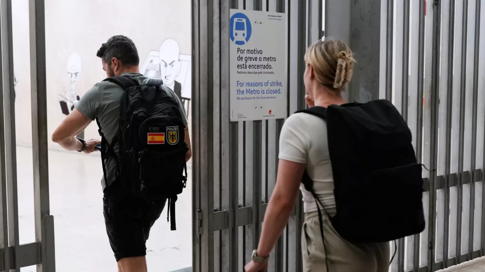 People entering the airport subway station walk past a sign announcing that due to a strike the subway will be closed, at the start of a 24-hour general strike to protest against a new labour package announced by the centre-right government, in Lisbon, Tuesday night, June 2, 2026. (AP Photo/Armando Franca)