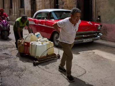 People transport containers of water in Havana, Wednesday, June 3, 2026. (AP Photo/Ramon Espinosa)