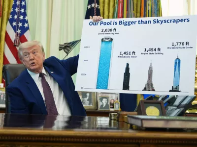 President Donald Trump holds a poster of the Lincoln Memorial Reflecting Pool, left, as he speaks in the Oval Office of the White House, Wednesday, June 3, 2026, in Washington. (AP Photo/Alex Brandon)