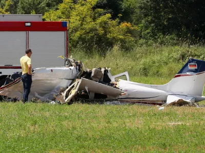 A person inspects a small plane which crashed near Medulin, Croatia, Thursday, June 4, 2026. (AP Photo/Goran Sebelic)