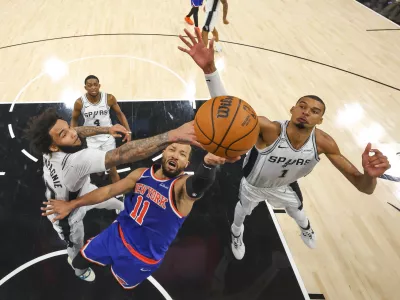 Jun 5, 2026; San Antonio, Texas, USA; New York Knicks guard Jalen Brunson (11) drives to the basket past San Antonio Spurs forward Julian Champagnie (30) and forward Victor Wembanyama (1) during game two of the 2026 NBA Finals at Frost Bank Center. Mandatory Credit: Gregory Shamus-Pool Photo via Imagn Images