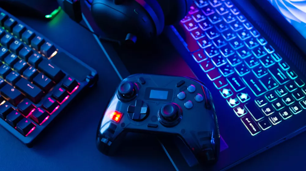 gamer work space concept, top view a gaming gear, mouse, keyboard, joystick on black table background.
