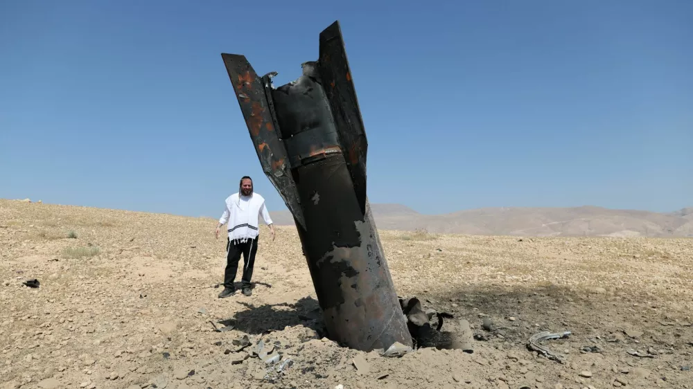 An Israeli ultra-Orthodox Jewish man reacts near a part of a missile protruding from the ground, following strikes from Iran, in the central Israeli-occupied West Bank, June 8, 2026. REUTERS/Ammar Awad / Foto: Ammar Awad