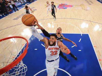 New York Knicks center Karl-Anthony Towns (32) dunks past San Antonio Spurs forward Victor Wembanyama during the first half of Game 4 of the NBA Finals basketball series, Monday, June 8, 2026, in New York. (Al Bello/Pool Photo via AP)