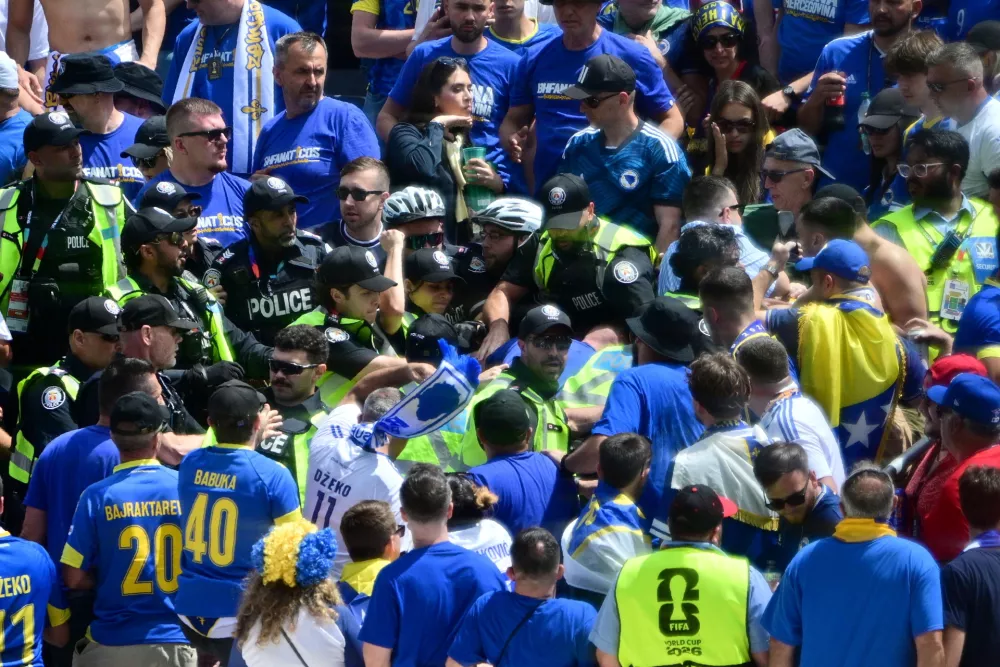Toronto Police officers interact with Bosnia fans in the stands before the World Cup Group B soccer match between Canada and Bosnia, Friday, June 12, 2026, in Toronto. (Sammy Kogan/The Canadian Press via AP)