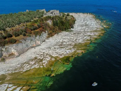 Pogled na italijansko jezero Garda, kjer so zaradi na povr&scaron;ju marsikje skale. 