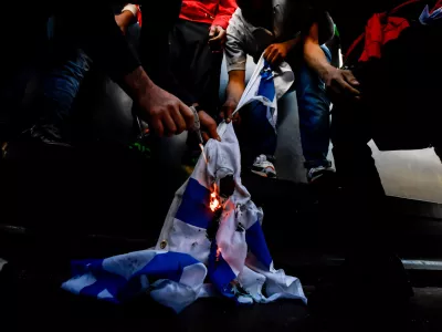 13 May 2021, Italy, Milan: Demonstrators burn an Israeli flag during a demonstration in solidarity with Palestinians amid the escalating flare-up of Israeli-Palestinian violence. Photo: Claudio Furlan/LaPresse via ZUMA Press/dpa