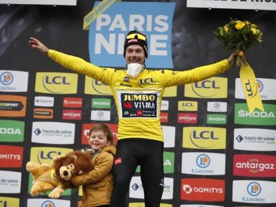 Slovenian rider Primoz Roglic of Jumbo Visma cycling team celebrates on the podium with his son Lev, after winning the Paris-Nice cycling race, in Nice, southern France, Sunday, March, 13, 2022. (AP Photo/Jean Francois Badias)