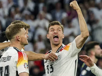 FILE - Germany's Thomas Mueller, right, celebrates during the Group A match between Germany and Scotland at the Euro 2024 soccer tournament in Munich, Germany, Friday, June 14, 2024. Germany forward Thomas M&uuml;ller has announced his retirement from international soccer after a 14-year career that included the 2014 World Cup title. (Christian Charisius/dpa via AP, File)