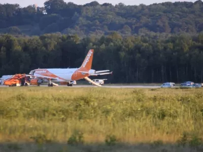 In this June 10, 2017 photo taken from video, a EasyJet plane stands at Cologne-Bonn airport, in Cologne Germany. German police are questioning three British citizens after their conversation during a flight to London prompted an EasyJet pilot to make an unscheduled stop in Cologne late Saturday. A spokesman for Cologne police says other passengers on the flight from the Slovenian capital Ljubljana overheard a conversation with "terrorist content" between the men, aged 31, 38 and 48. Airport authorities said in a statement that the 151 passengers on board disembarked the plane using emergency slides. (Thomas Kraus/dpa via AP)
