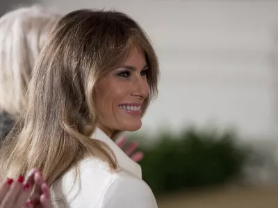FILE - This is a Wednesday, March 29, 2017, file photo of U.S. first lady Melania Trump smiles as she is recognized by President Donald Trump as he speaks at a women's empowerment panel, in the East Room of the White House in Washington. Melania Trump on Wednesday April 12, 2017, accepted an apology and damages from the publisher of the Daily Mail newspaper for reporting rumors about her time as a model. (AP Photo/Andrew Harnik, File)
